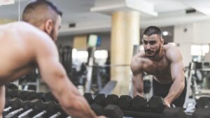 hombre mirándose en el espejo entrenando en el gimnasio