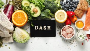 mesa con un cartel en el que pone Dash , verduras , carnes, huevos, legumbres, pescados y pasta integral alrededor